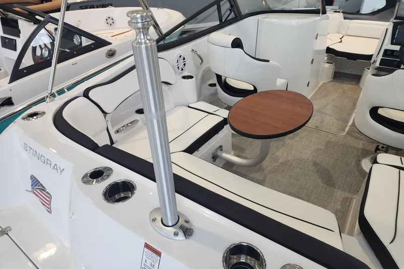 Slide: The Image of 2026 Stingray 211 DC boat interior with seating, table, and cup holders. - 29
