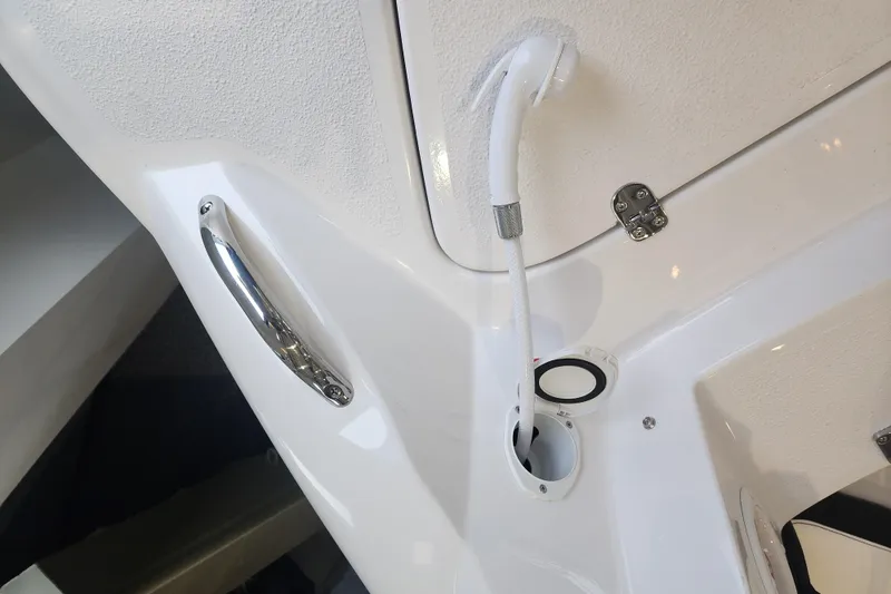 Slide: The Image of 2026 Stingray 211 DC boat showerhead and handle detail in white interior. - 30