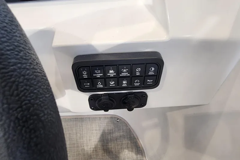 Slide: The Image of Control panel of a 2026 Stingray 211 DC boat with various switches and buttons. - 54