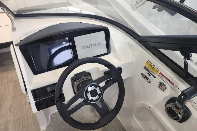 Slide: The Image of 2026 Stingray 211 DC boat dashboard with Garmin navigation system and steering wheel. - 55