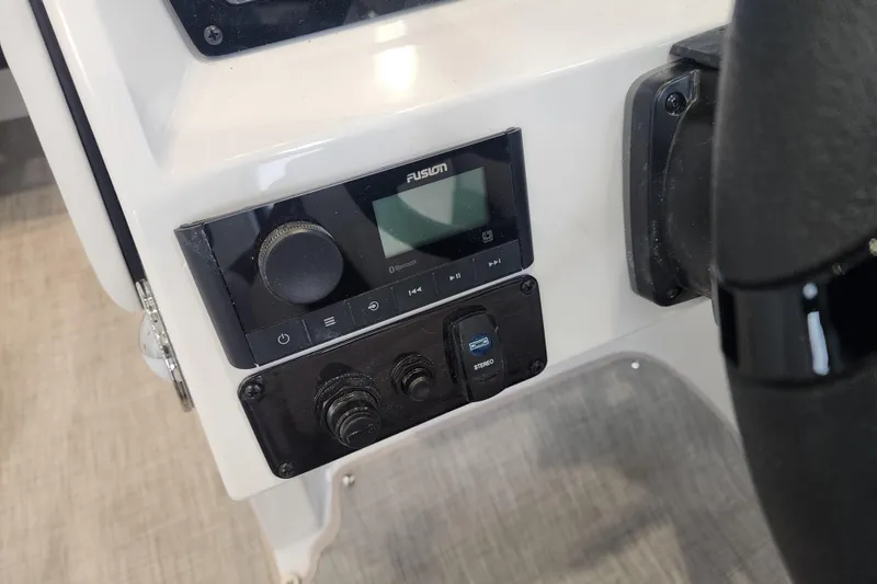 Slide: The Image of Control panel of 2026 Stingray 211 DC boat featuring Fusion stereo system. - 56