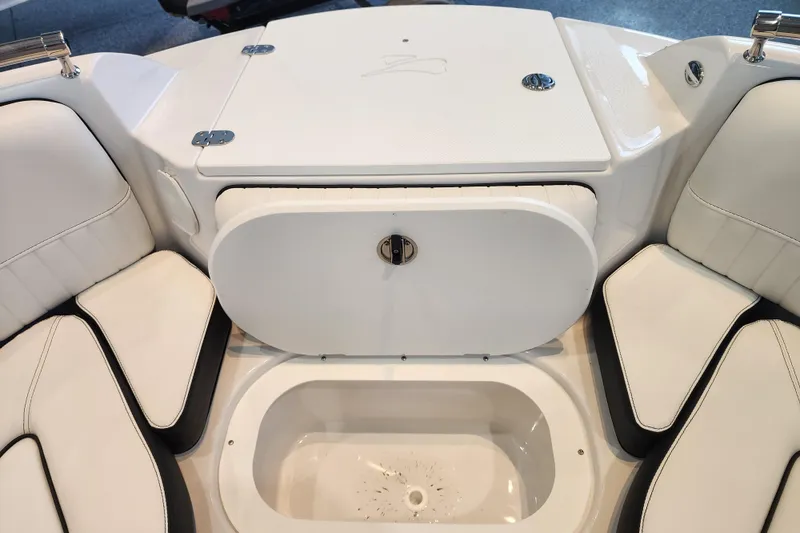 Slide: The Image of 2026 Stingray 211 DC boat interior with white seating and storage compartment. - 7
