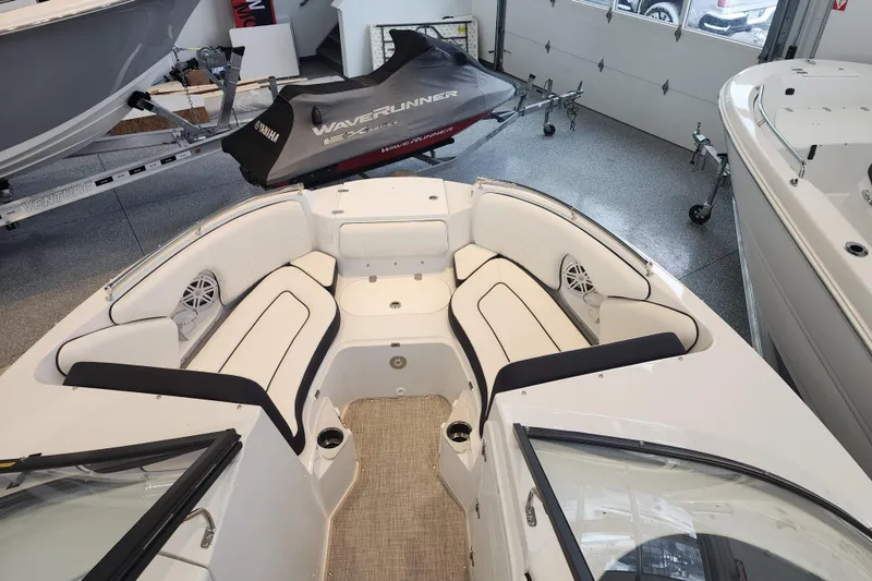 Slide: The Image of 2026 Stingray 211 DC boat interior with white seating and marine speakers. - 8