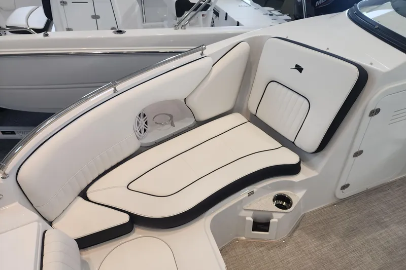 Slide: The Image of 2026 Stingray 211 DC boat interior with white cushioned seating and speaker detail. - 9
