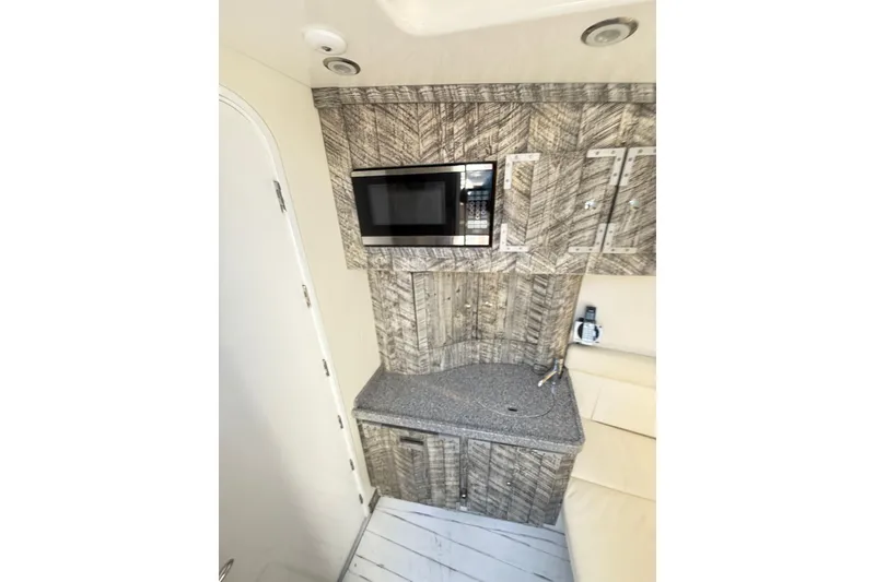 Slide: The Image of 2019 HCB 53 Suenos interior with microwave and wood-patterned cabinetry. - 16