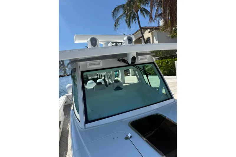 Slide: The Image of 2019 HCB 53 Suenos boat with advanced navigation equipment, docked near palm trees. - 28