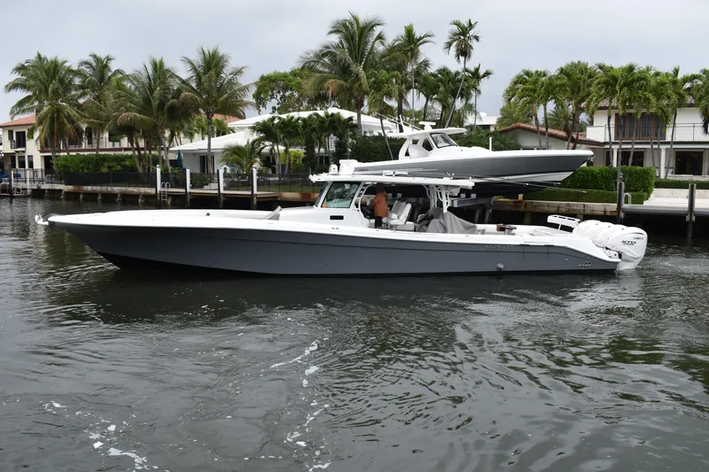 Slide: The Image of 2019 HCB 53 Suenos boat cruising on a calm waterway, surrounded by palm trees. - 3