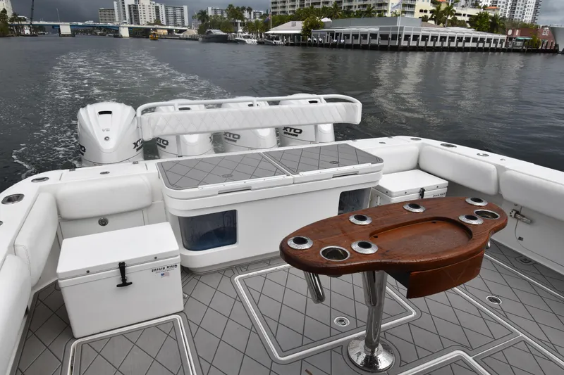 Slide: The Image of 2019 HCB 53 Suenos boat interior with seating, table, and outboard engines on water. - 35