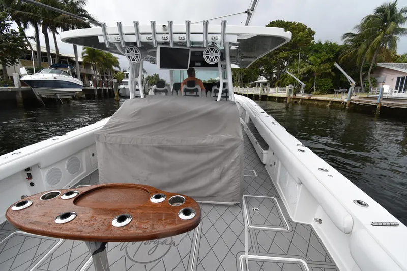 Slide: The Image of 2019 HCB 53 Suenos boat with sleek deck design, docked near waterfront homes. - 37