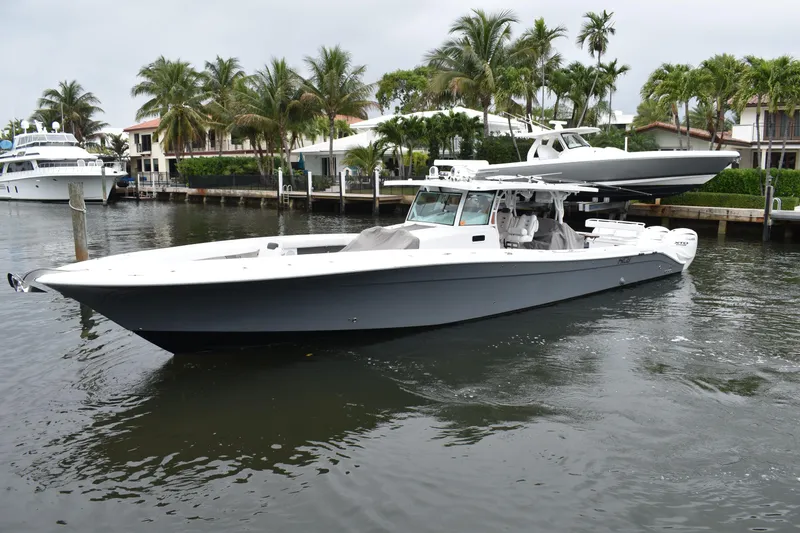 Slide: The Image of 2019 HCB 53 Suenos boat docked near palm trees and waterfront homes. - 4