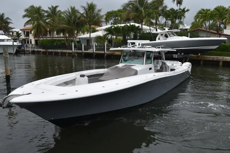 Slide: The Image of 2019 HCB 53 Suenos boat docked near palm trees and waterfront homes. - 5
