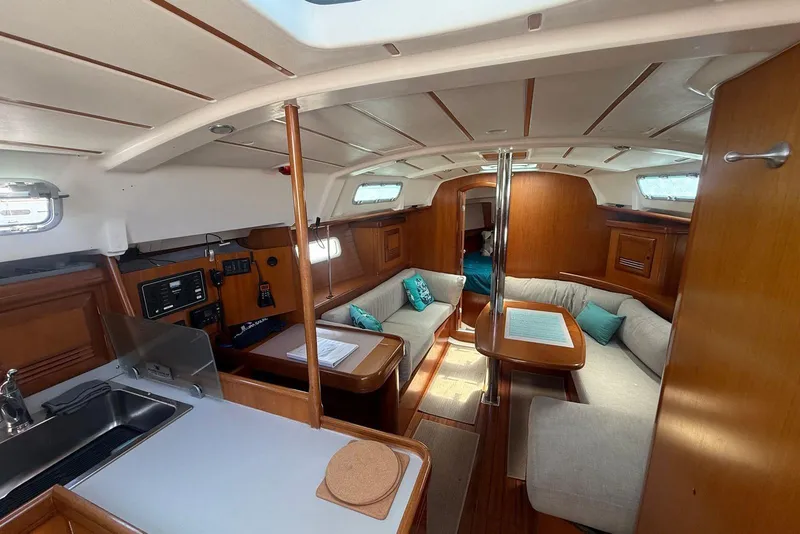 Slide: The Image of Interior of 2001 Beneteau Oceanis 361 sailboat, featuring cozy seating and wooden finishes. - 13