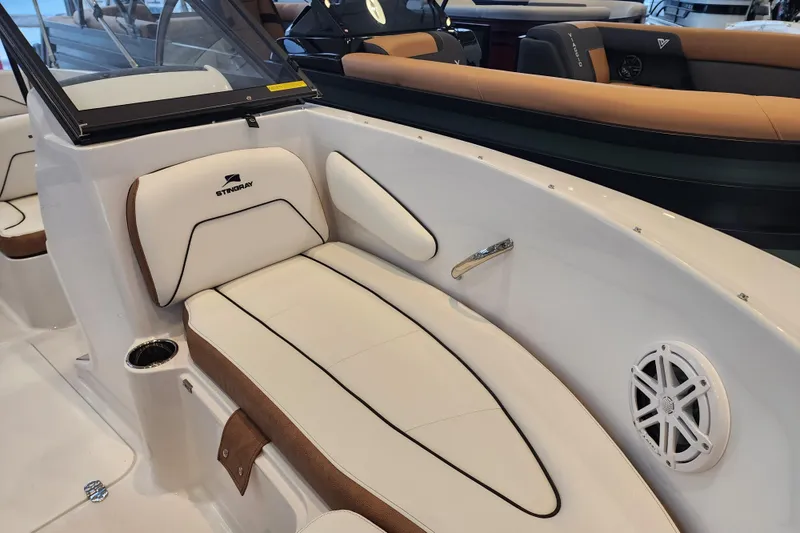 Slide: The Image of 2026 Stingray 172 DC boat interior with white and brown seating, cup holder, and speaker. - 27