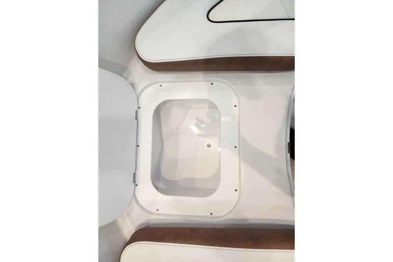 Slide: The Image of 2026 Stingray 172 DC boat interior storage compartment with white and brown seating. - 29