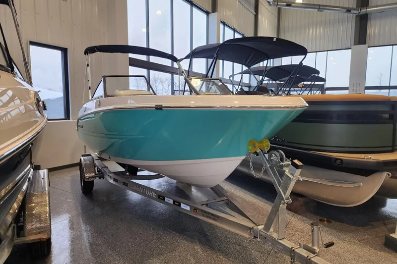 Slide: The Image of 2026 Stingray 172 DC boat in showroom, teal hull, on trailer. - 3