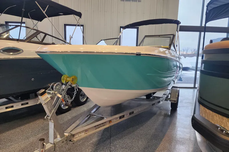 Slide: The Image of 2026 Stingray 172 DC boat on trailer in showroom, featuring sleek turquoise design. - 5