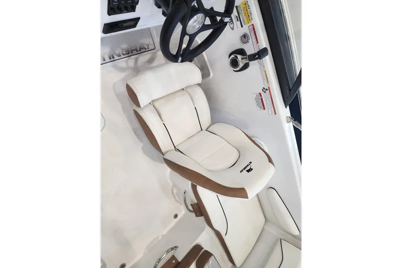 Slide: The Image of 2026 Stingray 172 DC boat interior with white and brown seating, steering wheel, and controls. - 9