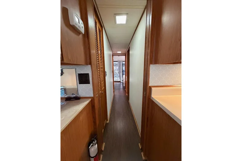Slide: The Image of Narrow hallway inside 1989 Sumerset 14x63 houseboat with wood paneling and modern decor. - 13