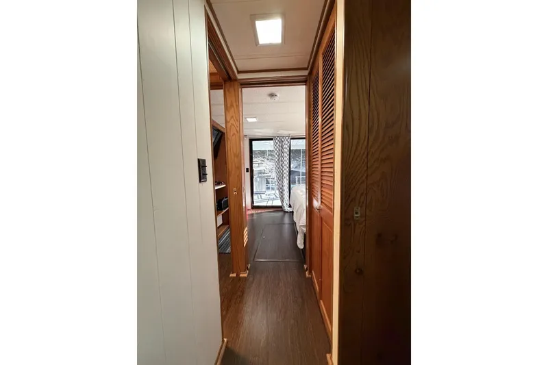 Slide: The Image of Narrow hallway inside 1989 Sumerset 14x63 houseboat, featuring wood paneling and natural light. - 15