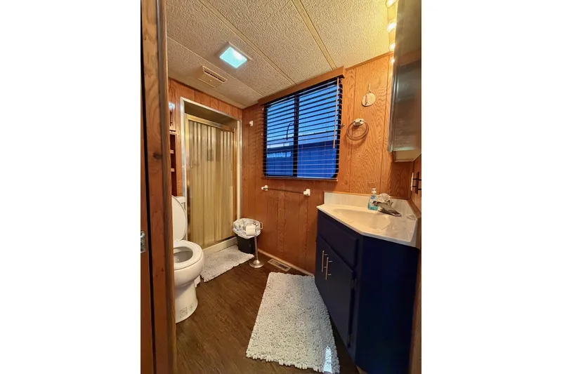 Slide: The Image of Bathroom interior of 1989 Sumerset 14x63 houseboat with wood paneling and modern fixtures. - 16