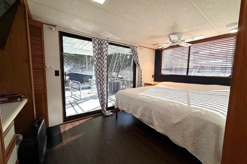 Slide: The Image of Bedroom interior of 1989 Sumerset 14x63 houseboat with large windows and sliding glass door. - 18