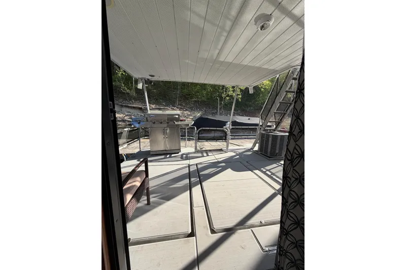 Slide: The Image of 1989 Sumerset 14x63 houseboat deck with grill and outdoor seating. - 20