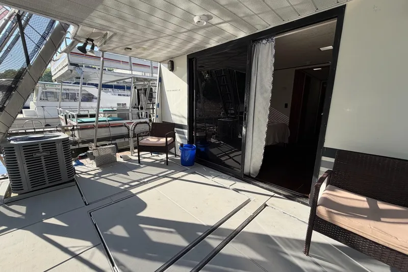 Slide: The Image of 1989 Sumerset 14x63 houseboat deck with seating and sliding glass door. - 21