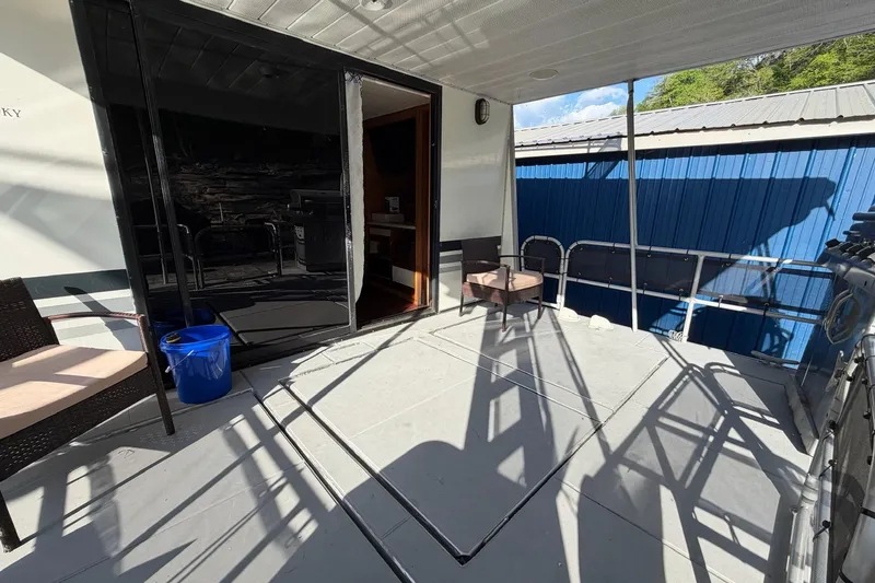 Slide: The Image of Outdoor deck of a 1989 Sumerset 14x63 houseboat with chairs and railing. - 22