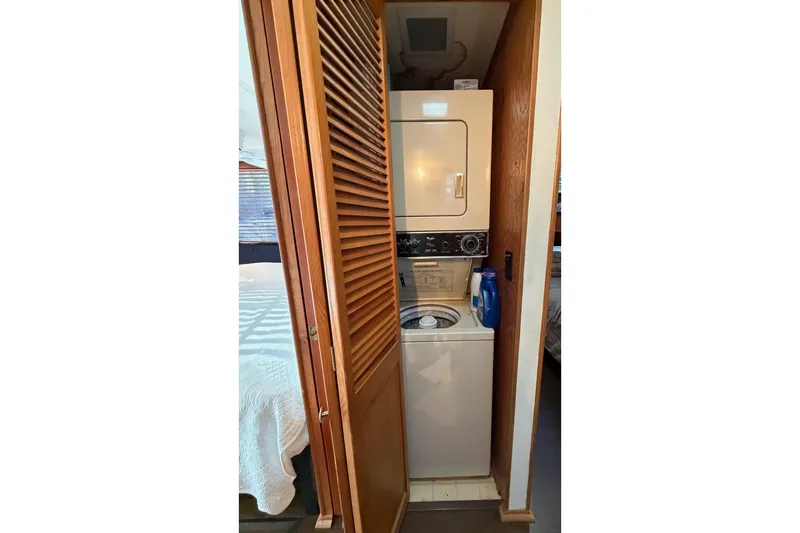 Slide: The Image of Stacked washer and dryer in 1989 Sumerset 14x63 houseboat with wooden louvered door. - 25
