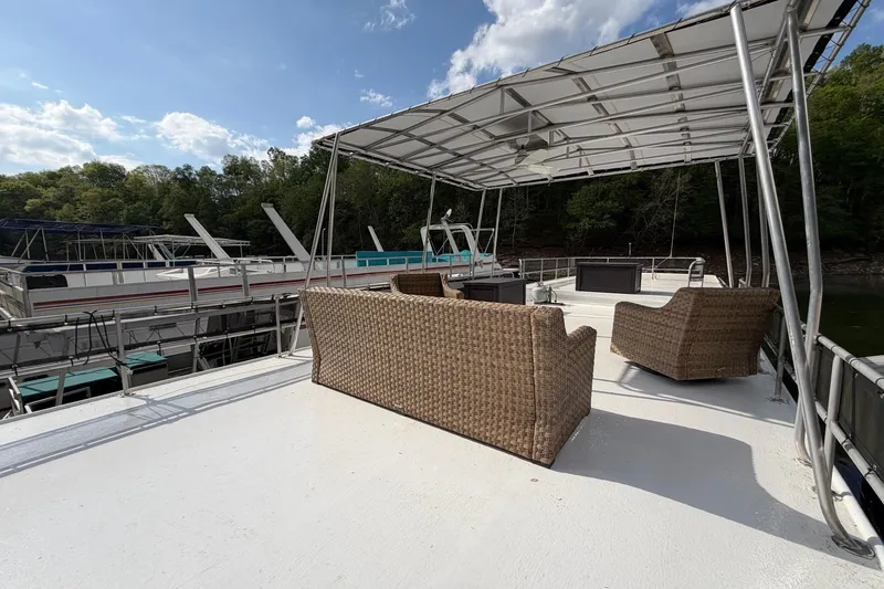 Slide: The Image of 1989 Sumerset 14x63 houseboat with outdoor seating on upper deck, surrounded by nature. - 36