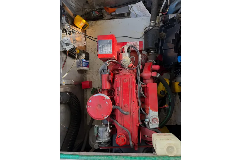 Slide: The Image of Engine compartment of a 1989 Sumerset 14x63 houseboat, featuring a red engine. - 40