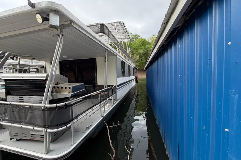 Slide: The Image of 1989 Sumerset 14x63 houseboat docked beside a blue metal wall. - 47