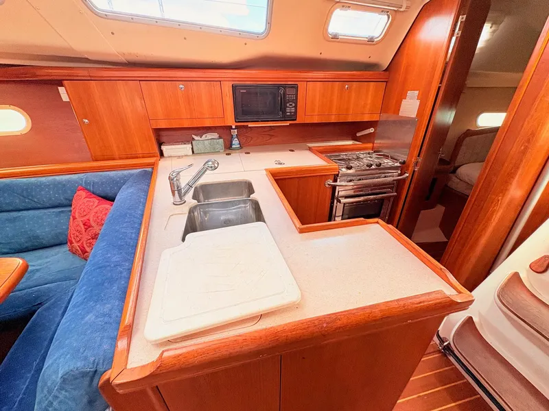 Slide: The Image of Interior of a 2003 Hunter 356 yacht with kitchen and seating area. - 21