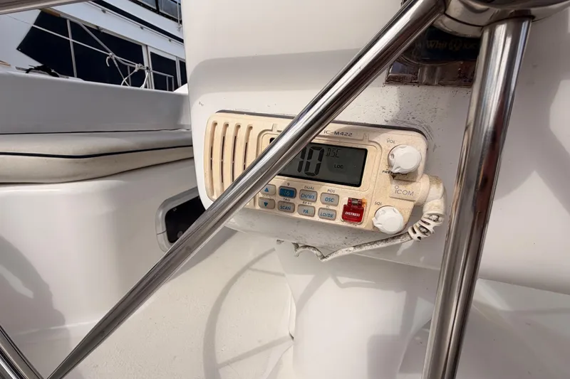 Slide: The Image of VHF radio on 1998 Hunter Legend 40.5 sailboat cockpit, surrounded by stainless steel railings. - 28