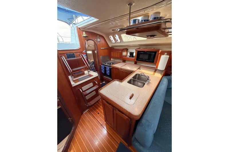 Slide: The Image of Interior of 1998 Hunter Legend 40.5 sailboat with wooden cabinetry and modern kitchen amenities. - 34