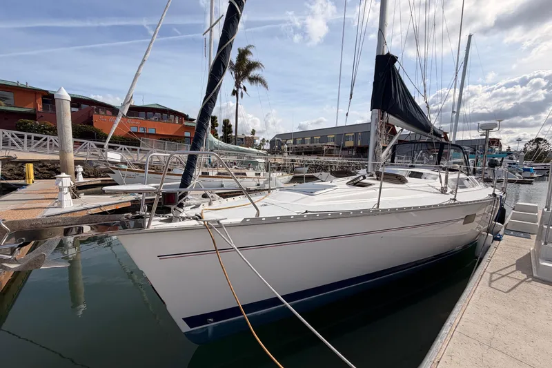 Slide: The Image of 1998 Hunter Legend 40.5 sailboat docked at marina under cloudy sky. - 5