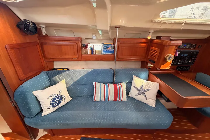 Slide: The Image of Interior of a 1998 Hunter Legend 40.5 yacht with blue sofa and nautical-themed pillows. - 52