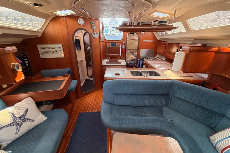 Slide: The Image of Interior of a 1998 Hunter Legend 40.5 sailboat with cozy seating and wooden finishes. - 61
