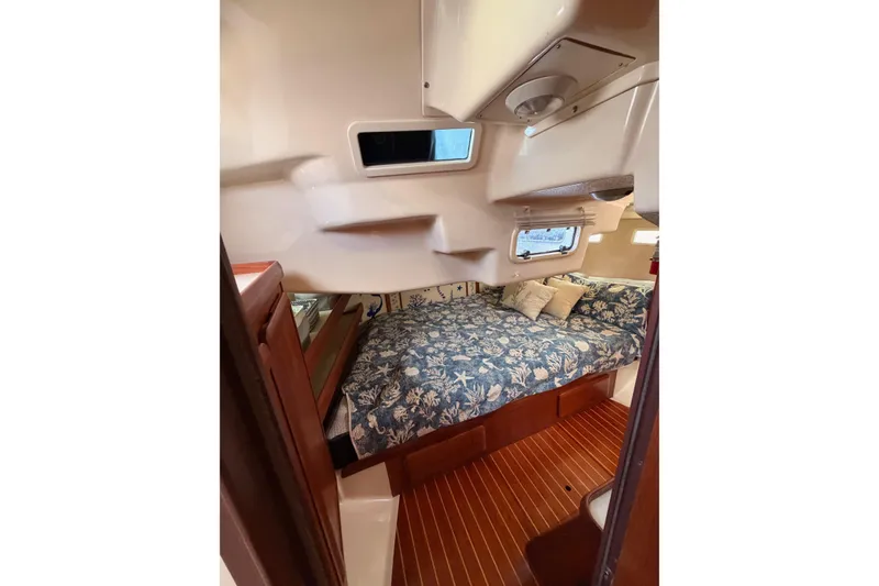 Slide: The Image of 1998 Hunter Legend 40.5 yacht cabin with floral bedding and wooden flooring. - 67
