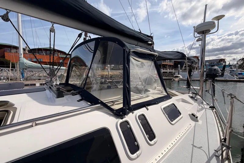 Slide: The Image of 1998 Hunter Legend 40.5 sailboat docked at a marina under a partly cloudy sky. - 7