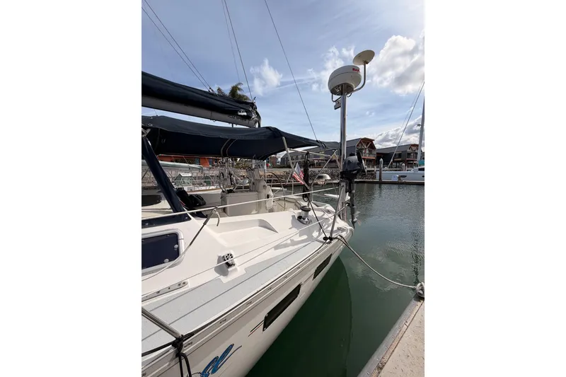 Slide: The Image of 1998 Hunter Legend 40.5 sailboat docked in a marina under a partly cloudy sky. - 8
