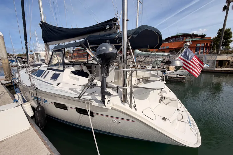 Slide: The Image of 1998 Hunter Legend 40.5 sailboat docked with American flag and Yamaha motor. - 9