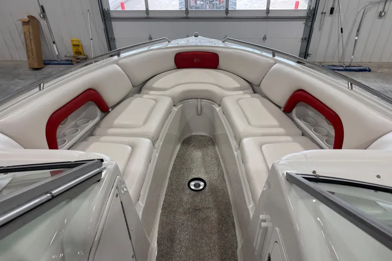 Slide: The Image of 2003 Crownline 270 BR boat interior with white and red seating in a garage. - 10