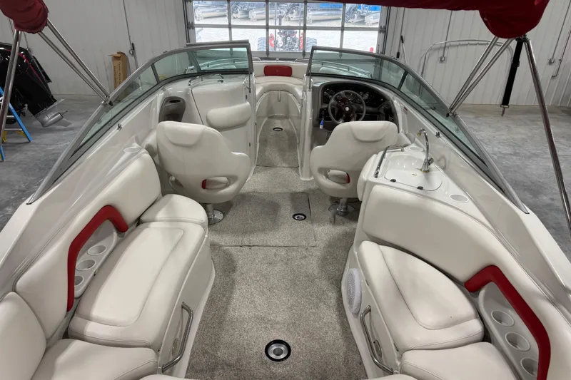 Slide: The Image of 2003 Crownline 270 BR boat interior with white seating and steering console. - 7