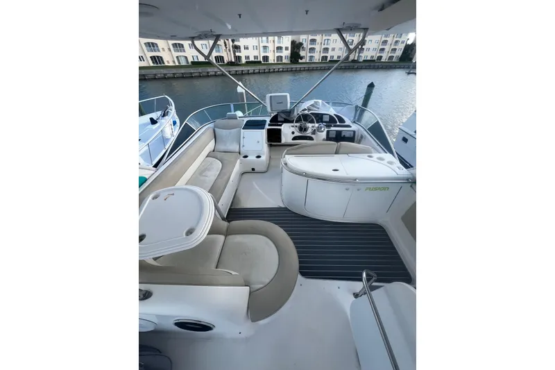 Slide: The Image of 2001 Maxum 4600 SCB Limited Edition yacht interior with seating and helm, docked by waterfront. - 11