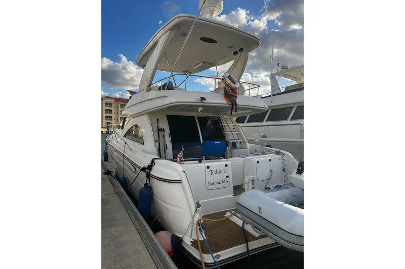 Slide: The Image of 2001 Maxum 4600 SCB Limited Edition yacht docked under a partly cloudy sky. - 4