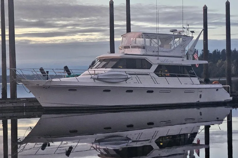 The Image of Luxury yacht Symbol 55, 1995 model, docked at serene marina during sunset. - 1