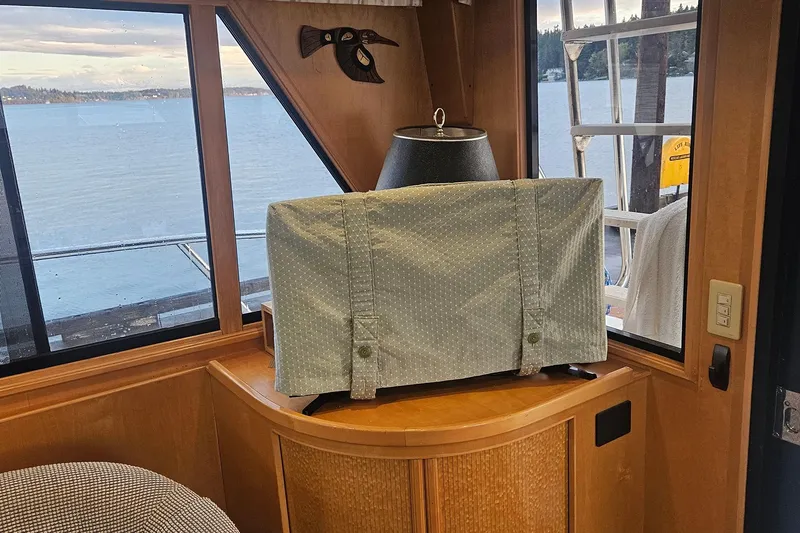 Slide: The Image of Cozy boat interior with covered TV, scenic lake view, and wooden decor. - 15