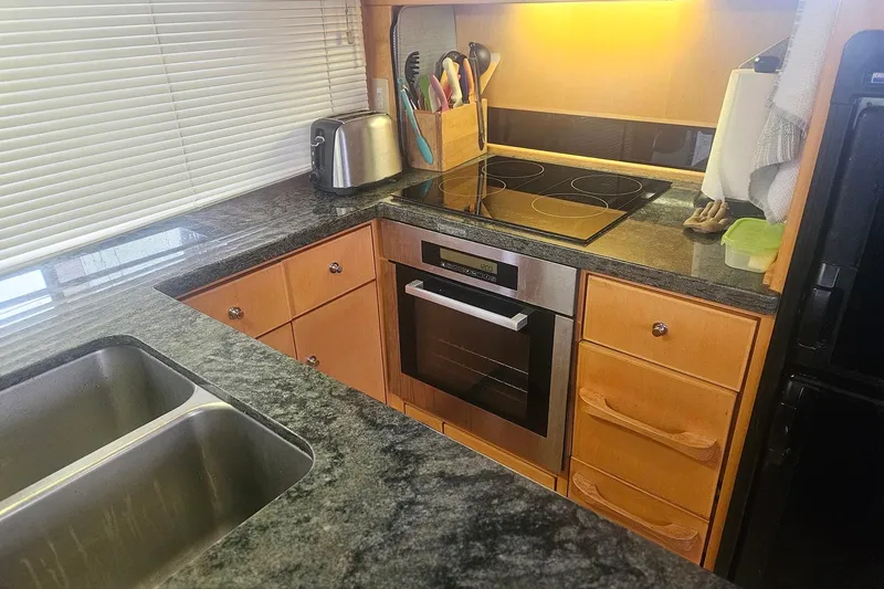 Slide: The Image of Modern kitchen with granite countertops, stainless steel appliances, and wooden cabinetry in a Symbol 55 model. - 17