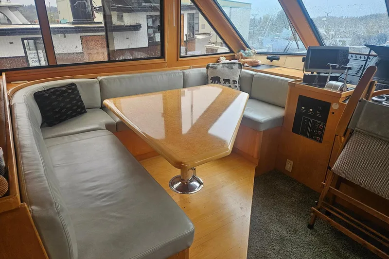 Slide: The Image of Cozy interior of a 1995 Symbol 55 yacht with a wooden table and cushioned seating. - 21